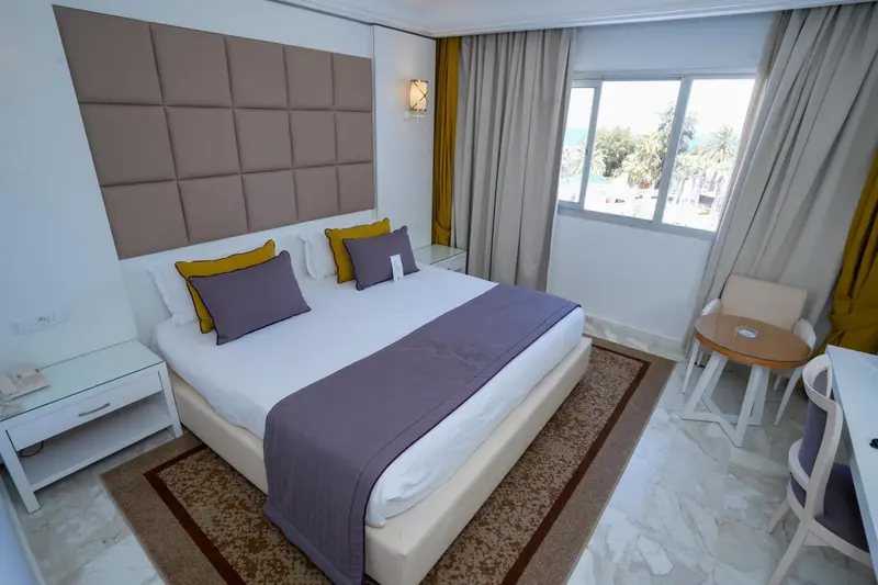 Une chambre lumineuse avec un grand lit et une décoration sobre.