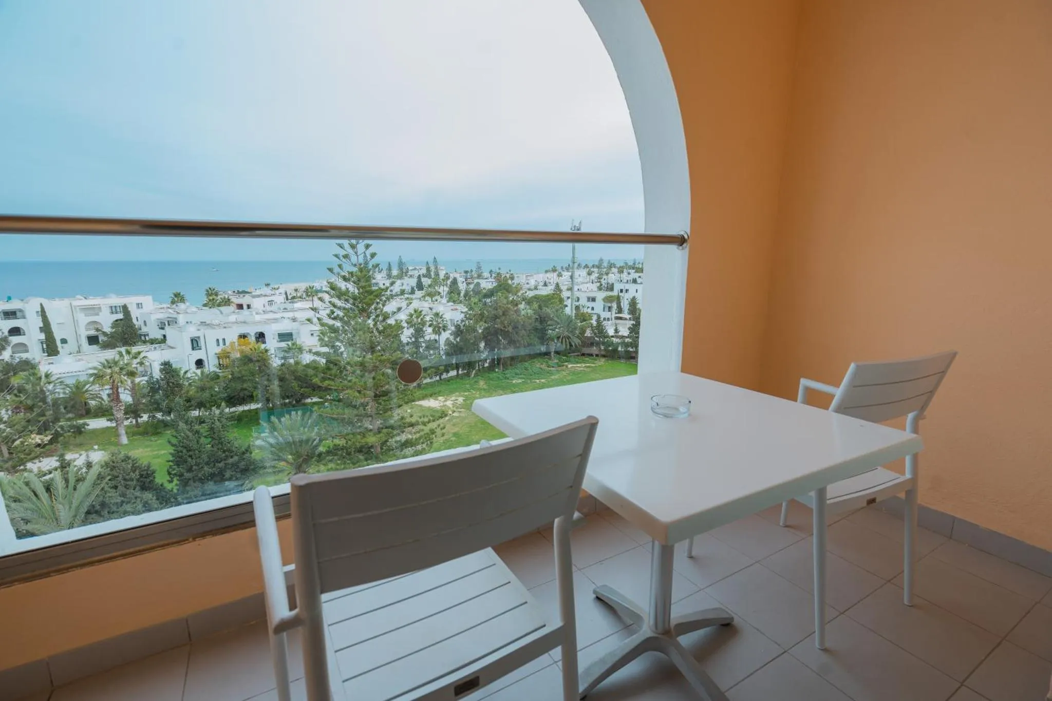 Vue sur la mer depuis une terrasse avec mobilier de jardin.