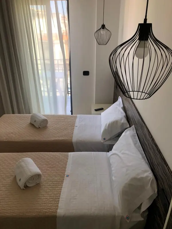 Une chambre lumineuse avec deux lits simples et une décoration moderne.