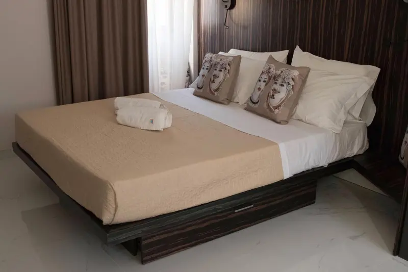 Une chambre avec un grand lit recouvert d'une courtepointe et de coussins.