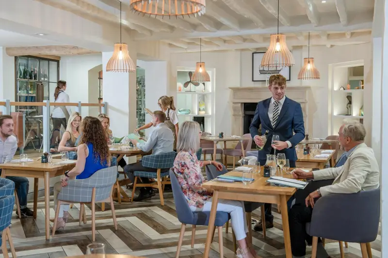 Une salle de restaurant lumineuse avec des tables et des clients.