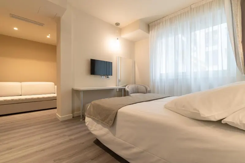 Une chambre lumineuse avec un canapé et un lit.