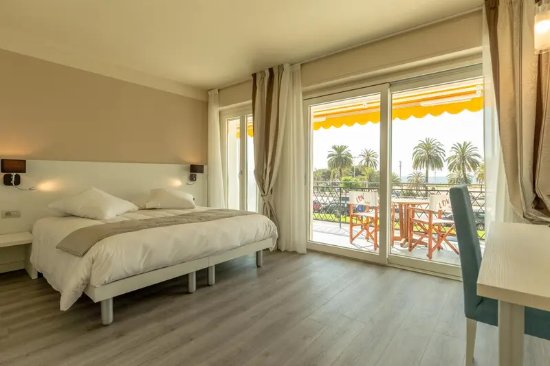 Une chambre lumineuse avec un lit double et un accès à une terrasse.