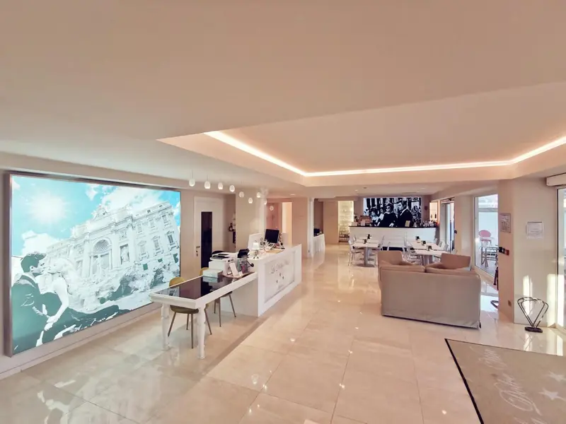 Un hall d'accueil lumineux avec un comptoir de réception et un coin salon.