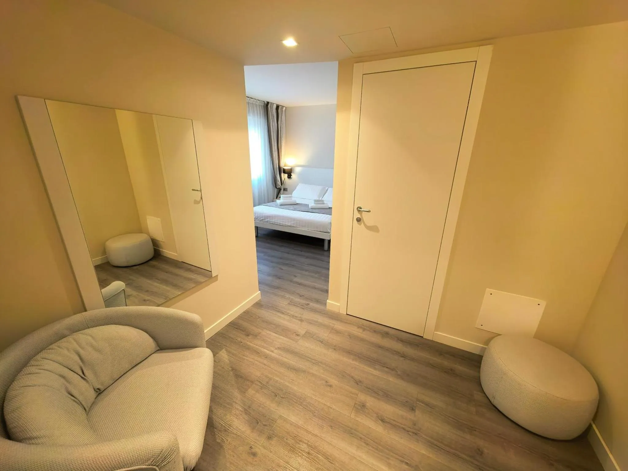 Espace de détente avec canapé et miroir dans une chambre.
