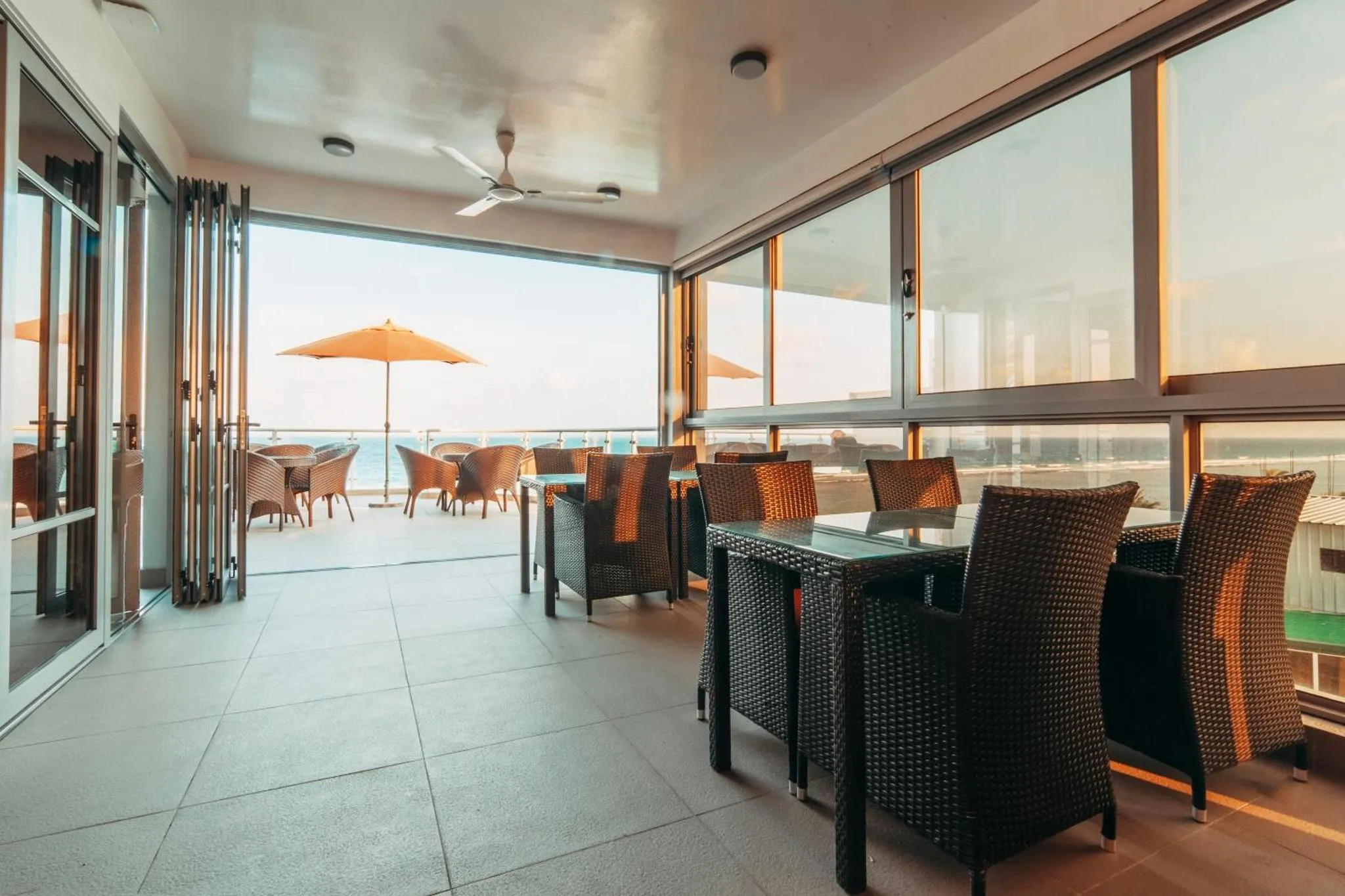 Terrasse aménagée avec tables et chaises donnant sur une vue mer.