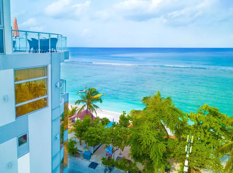 Vue aérienne sur un bâtiment blanc et la mer turquoise.