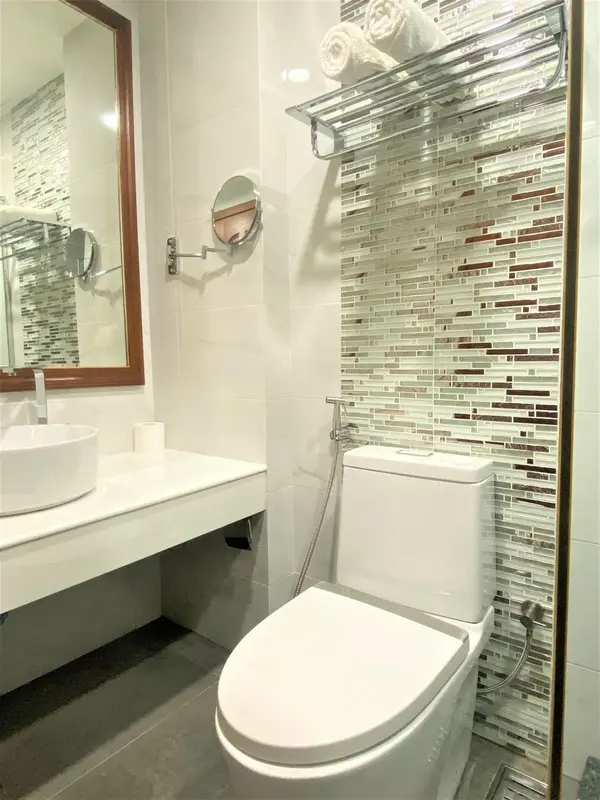 Une salle de bain moderne avec des carreaux décoratifs et des sanitaires blancs.
