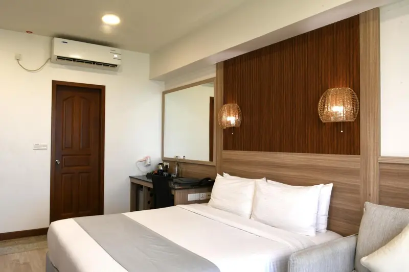 Une chambre lumineuse avec un grand lit et un décor mural en bois.