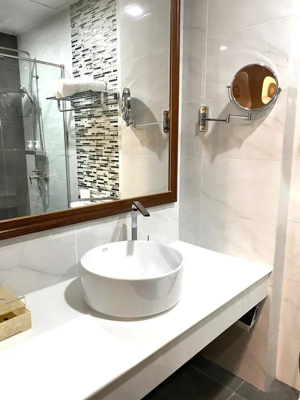 Une salle de bain moderne avec une douche à l'italienne et un lavabo sur un plan vasque.