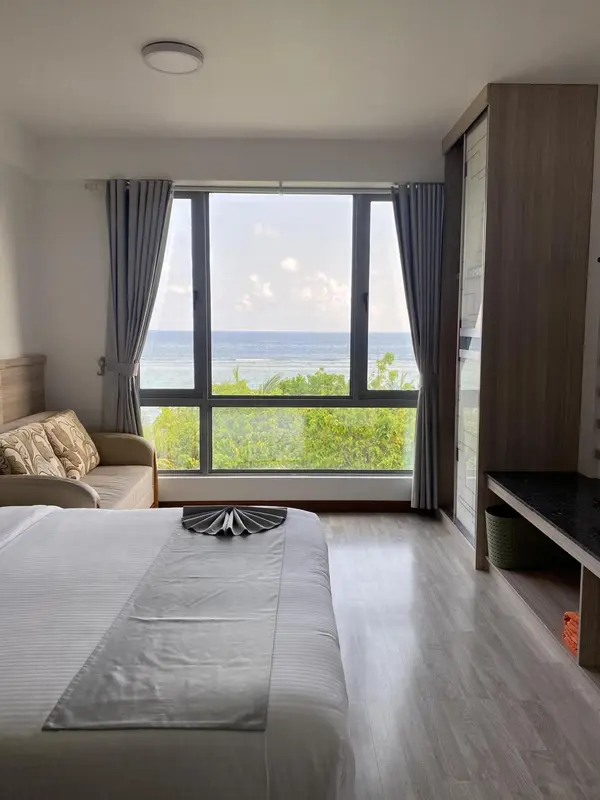 Une chambre lumineuse avec un grand lit et une vue sur la mer.
