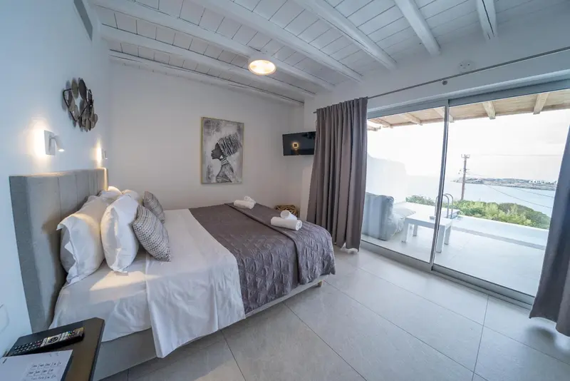 Une chambre lumineuse avec un grand lit et une vue sur la mer.