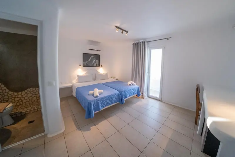 Une chambre lumineuse avec deux lits simples et un bureau.