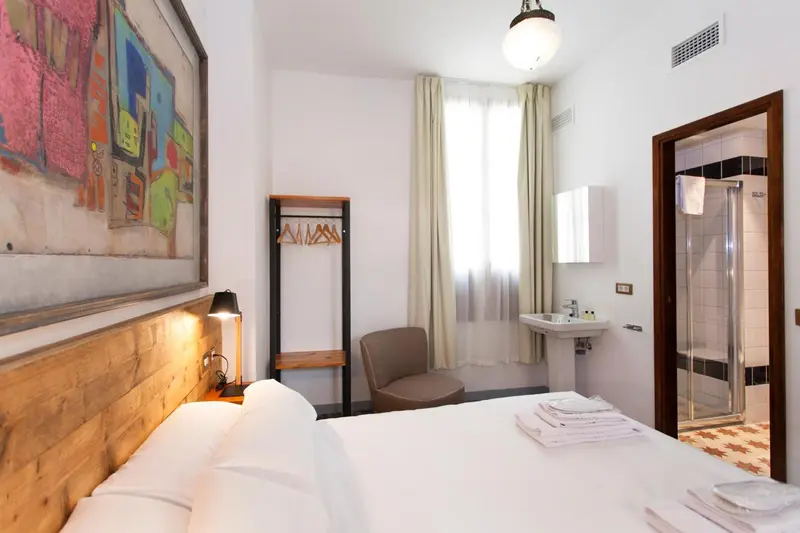Une chambre lumineuse avec un lit et un coin salon.