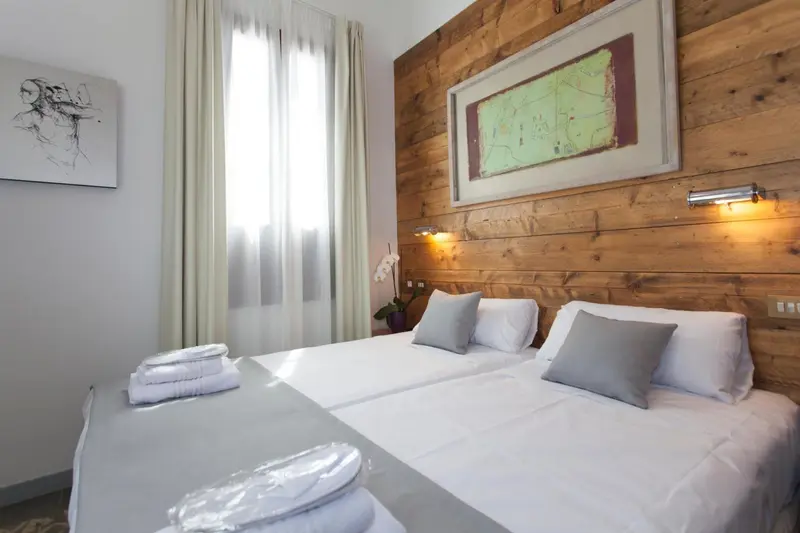 Une chambre lumineuse avec un lit double et un mur en bois.