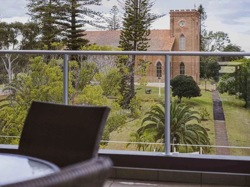 Vue d'une église depuis une terrasse avec mobilier d'extérieur.