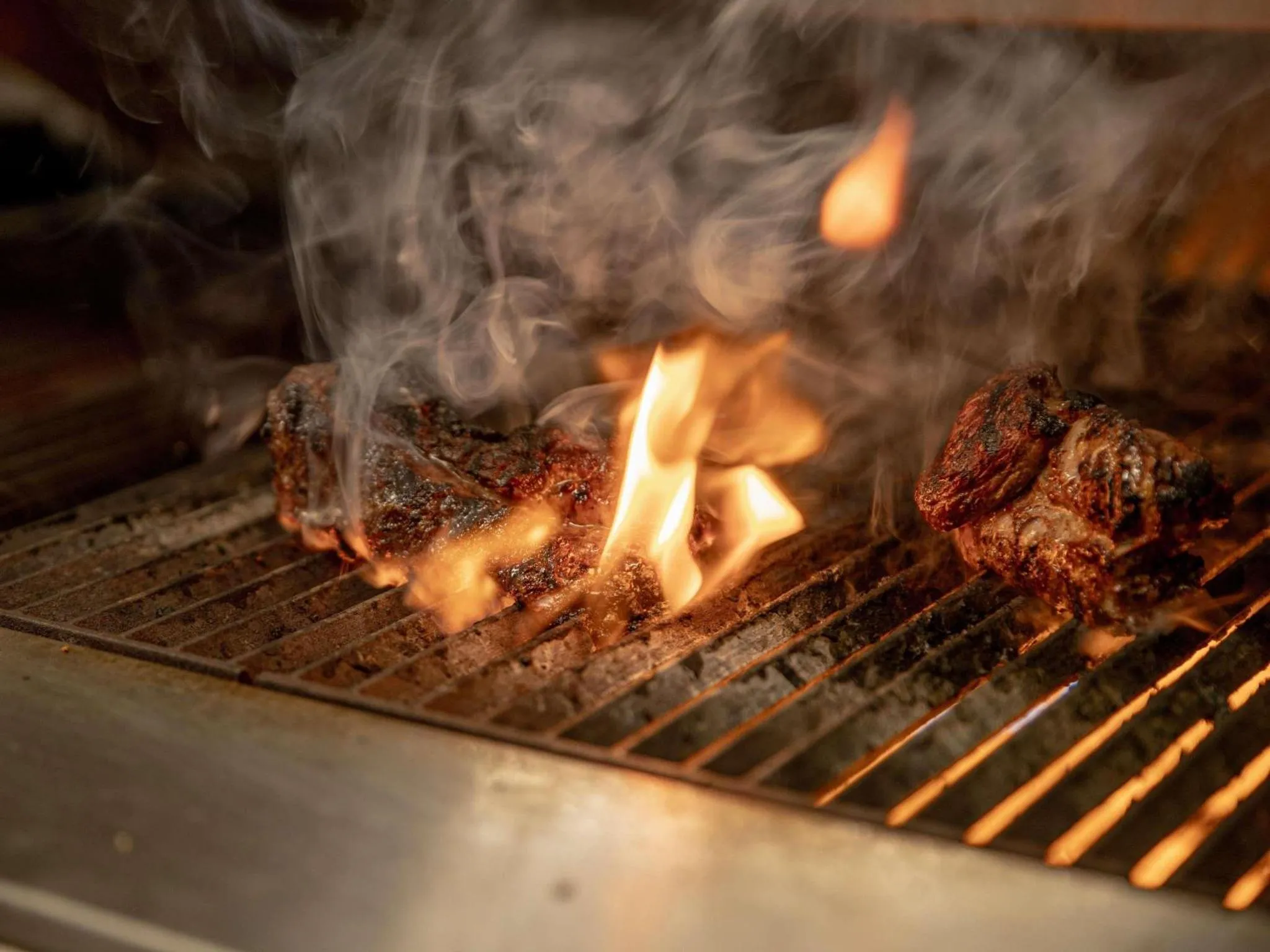 Viandes grillées sur un barbecue en plein air.