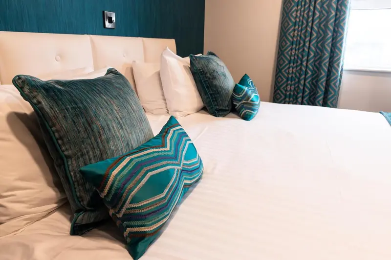 Un lit recouvert de coussins décoratifs dans une chambre.