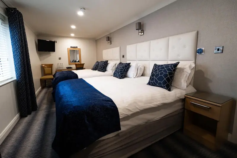 Une chambre avec deux lits simples et une décoration sobre.