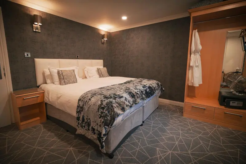 Une chambre avec un grand lit recouvert d'une couverture décorative et des oreillers.