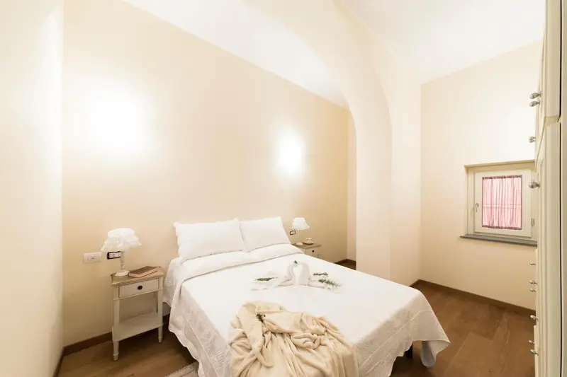 Une chambre lumineuse avec un lit double et une décoration sobre.