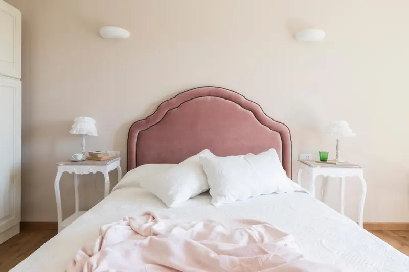 Une chambre à coucher avec un grand lit recouvert de draps blancs et de coussins.