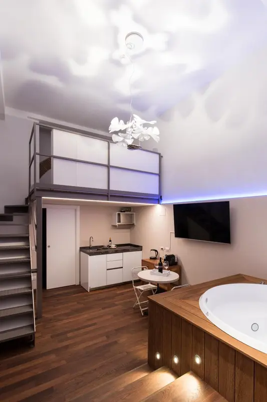 Une chambre mansardée lumineuse avec kitchenette et jacuzzi.