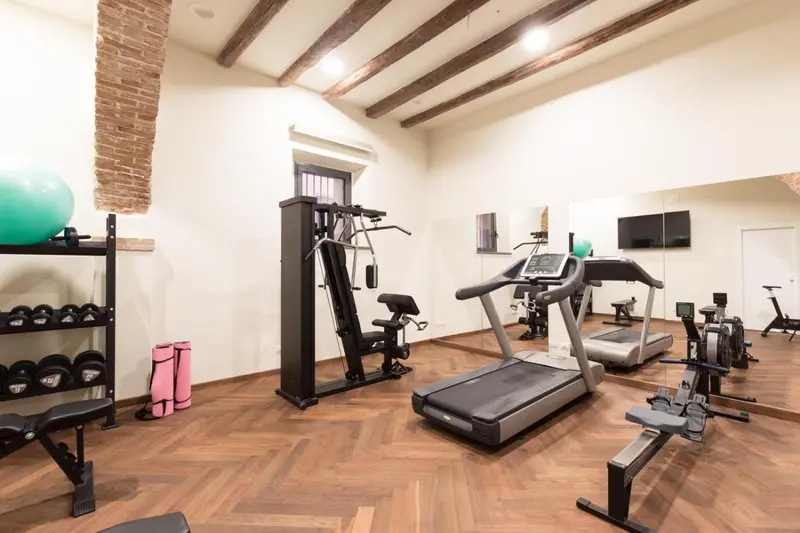 Une salle de sport lumineuse avec des équipements de musculation et de cardio.