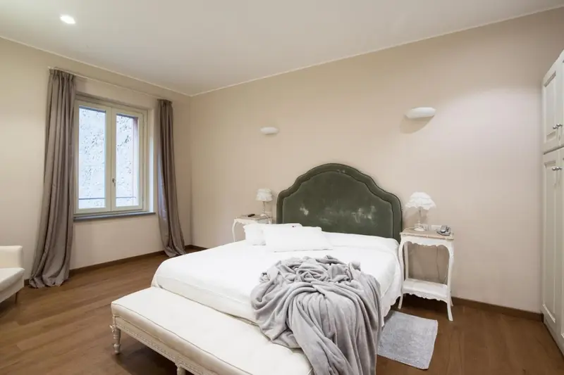 Une chambre lumineuse avec un grand lit recouvert d'une courtepointe.