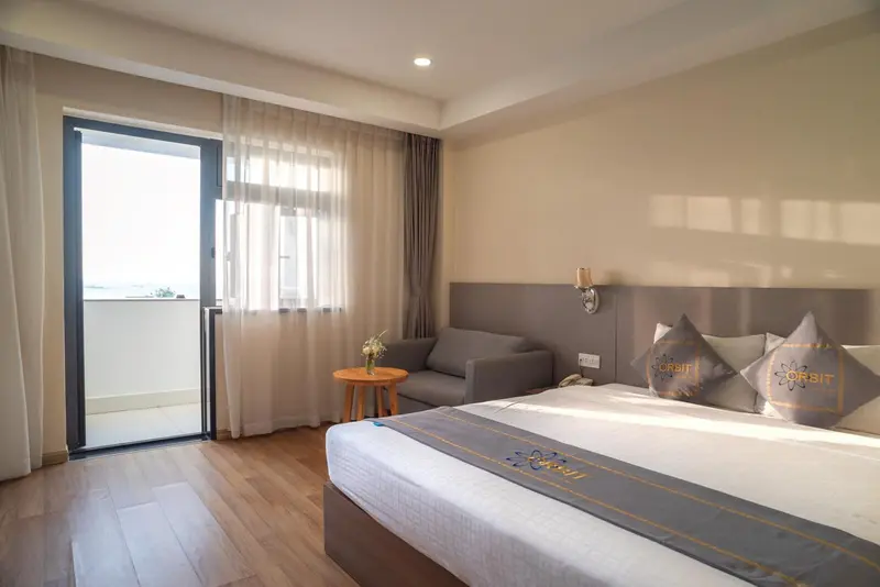 Une chambre lumineuse avec un lit confortable et un coin salon.