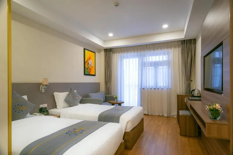 Une chambre lumineuse avec deux lits simples et un coin salon.