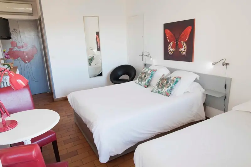 Une chambre lumineuse avec un lit double et un lit simple.