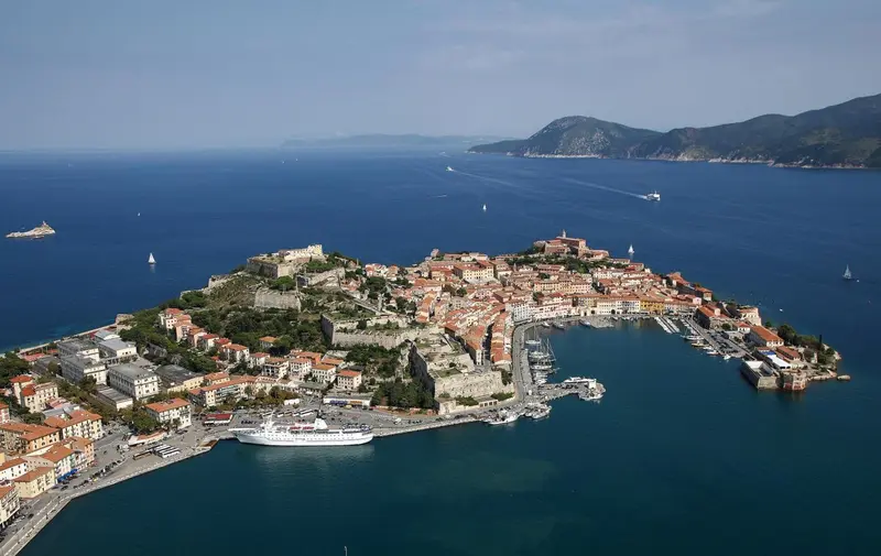 Vue aérienne d'une ville côtière fortifiée entourée de mer.