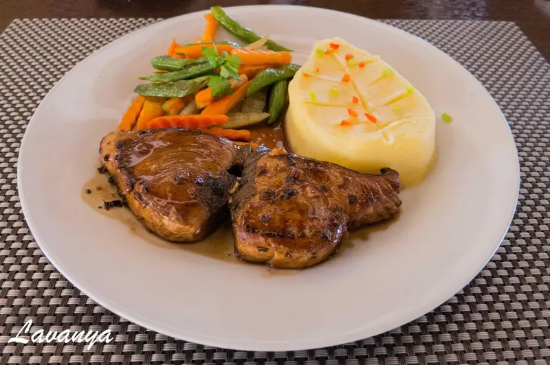 Assiette de poisson grillé accompagné de légumes et de pommes de terre.