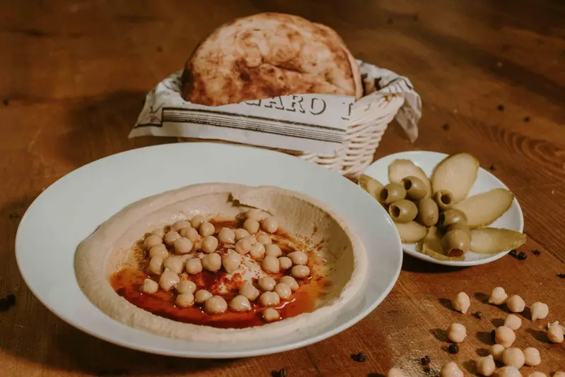 Assiette de houmous, de pois chiches, d'olives et de pain pita.
