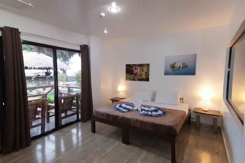 Une chambre lumineuse avec un grand lit et un accès à une terrasse.