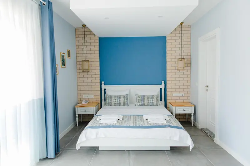 Une chambre lumineuse avec un grand lit recouvert d'une courtepointe décorative.