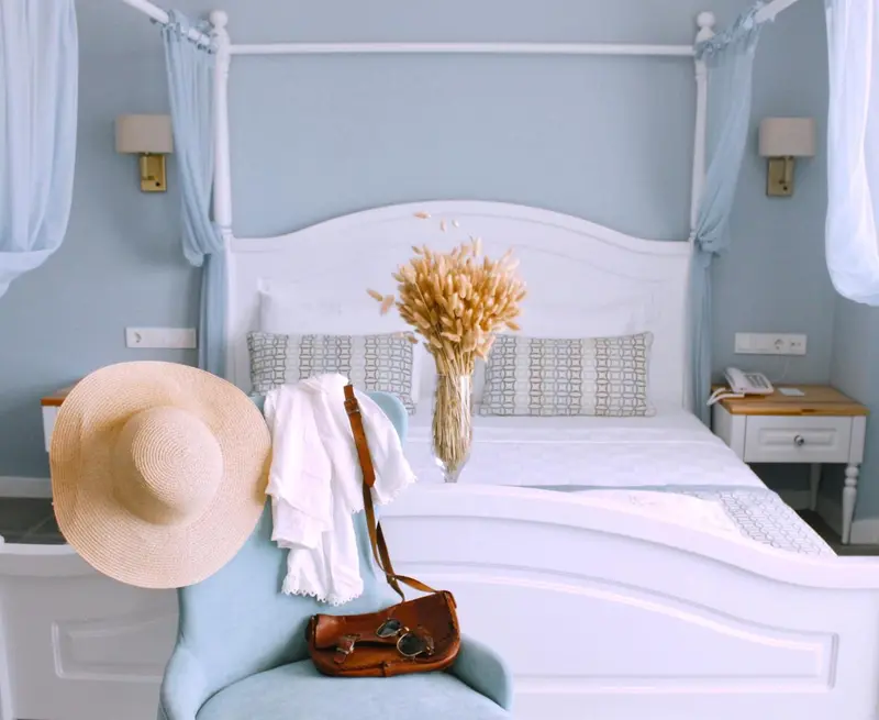 Une chambre lumineuse avec un grand lit à baldaquin et une décoration soignée.
