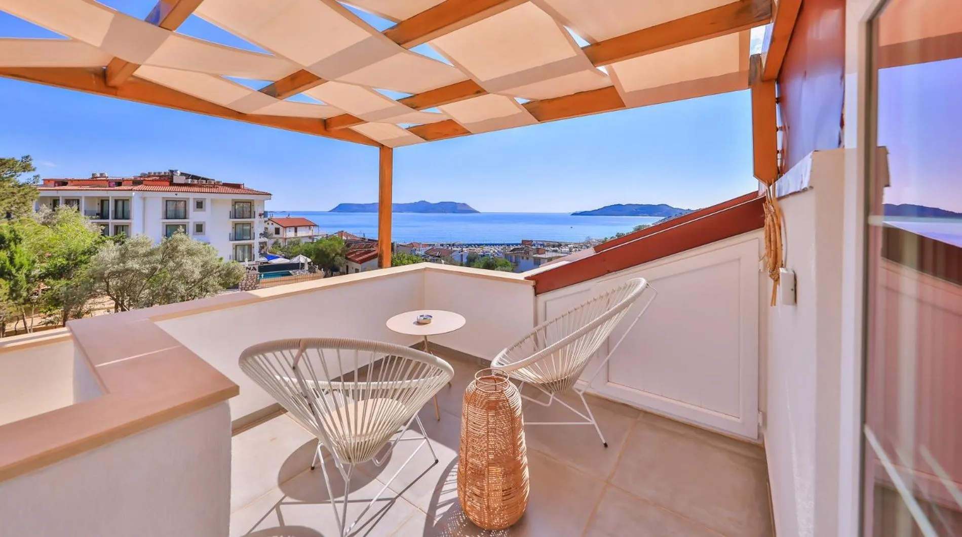 Terrasse avec mobilier d'extérieur donnant sur une vue mer et un paysage urbain.