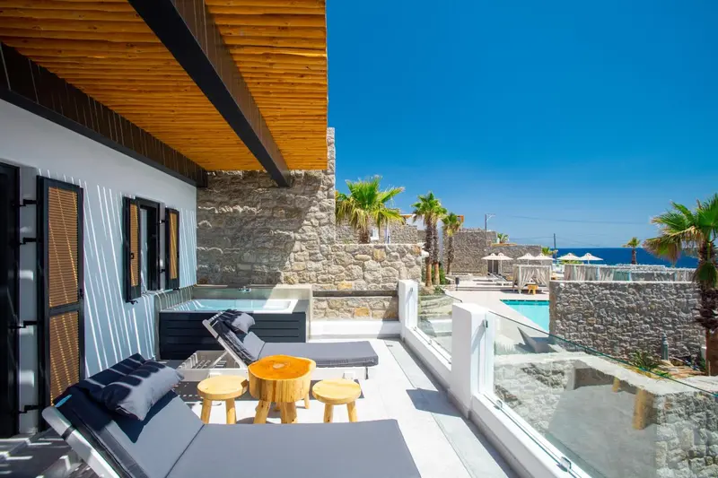 Terrasse aménagée avec salon de jardin et jacuzzi, vue sur la mer.
