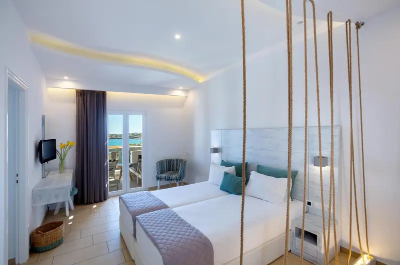 Chambre lumineuse avec un grand lit et une décoration moderne.