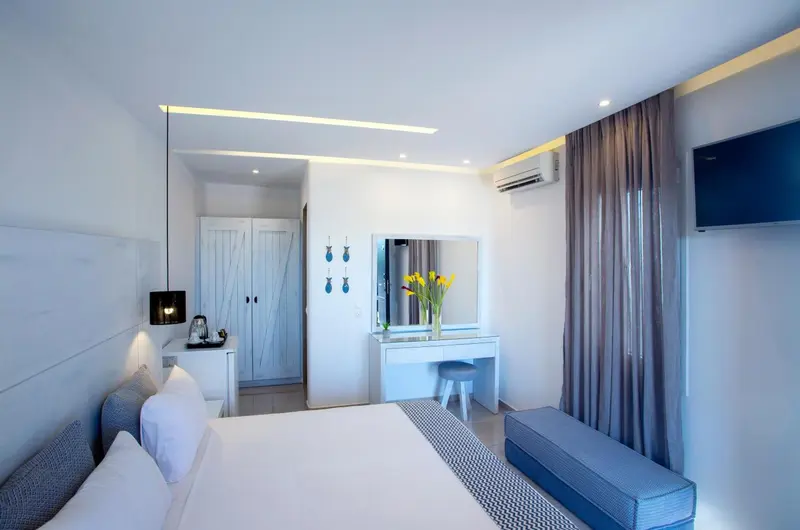 Une chambre lumineuse avec un grand lit et un coin coiffeuse.