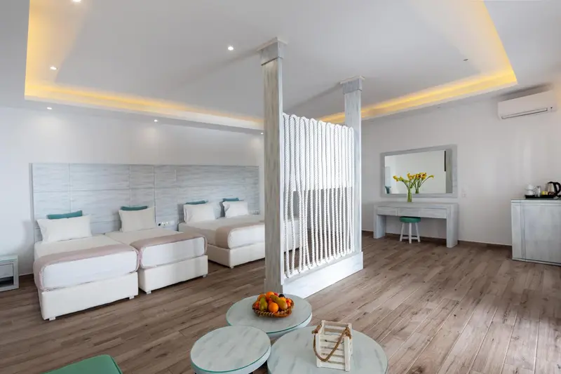 Chambre lumineuse avec deux lits simples et un espace détente.