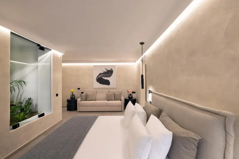 Une chambre lumineuse avec un grand lit et un canapé.