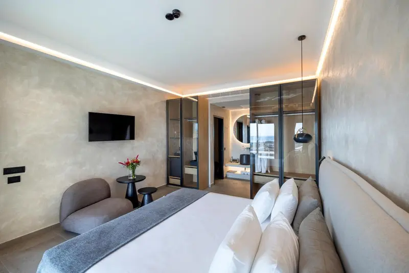 Une chambre lumineuse avec un grand lit et un espace détente.