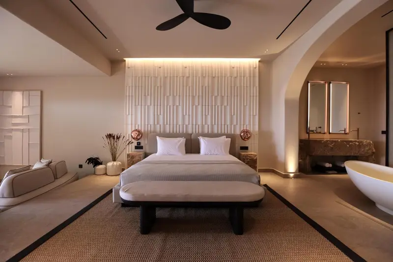 Une chambre lumineuse avec un grand lit et une baignoire.