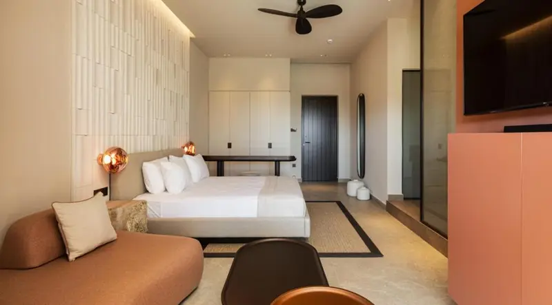 Une chambre lumineuse avec un grand lit et un coin salon.