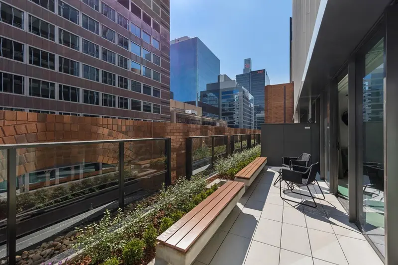 Terrasse aménagée avec mobilier de jardin et végétation.