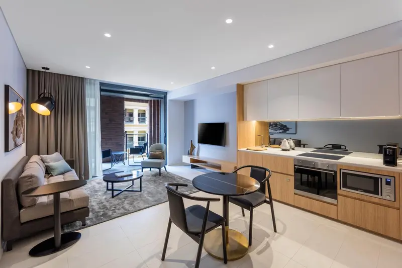 Espace de vie moderne avec coin repas et cuisine équipée.