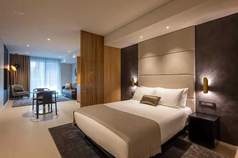 Une chambre moderne avec un grand lit et un espace salon.